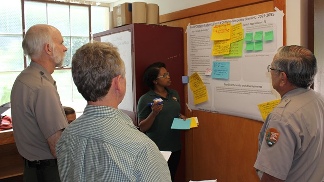 Staff talking around a planning board covered with notes 