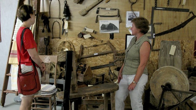 two women looking at a wall of various tools