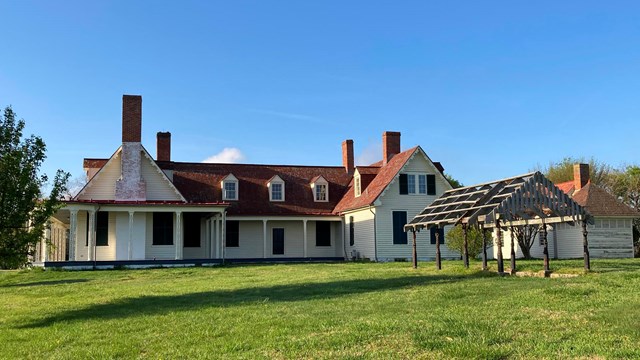 White two-story building with a red roof. 