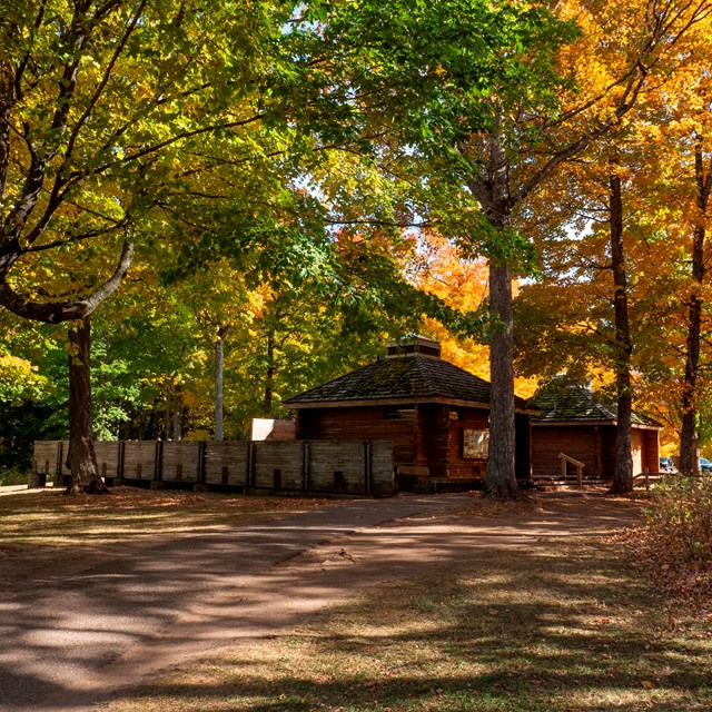 A wood pavilion beneath autumn leaves