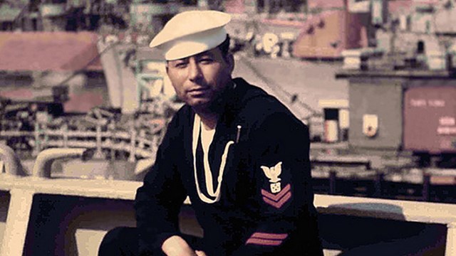 An historic photo of a young African American man in a sailor uniform. 