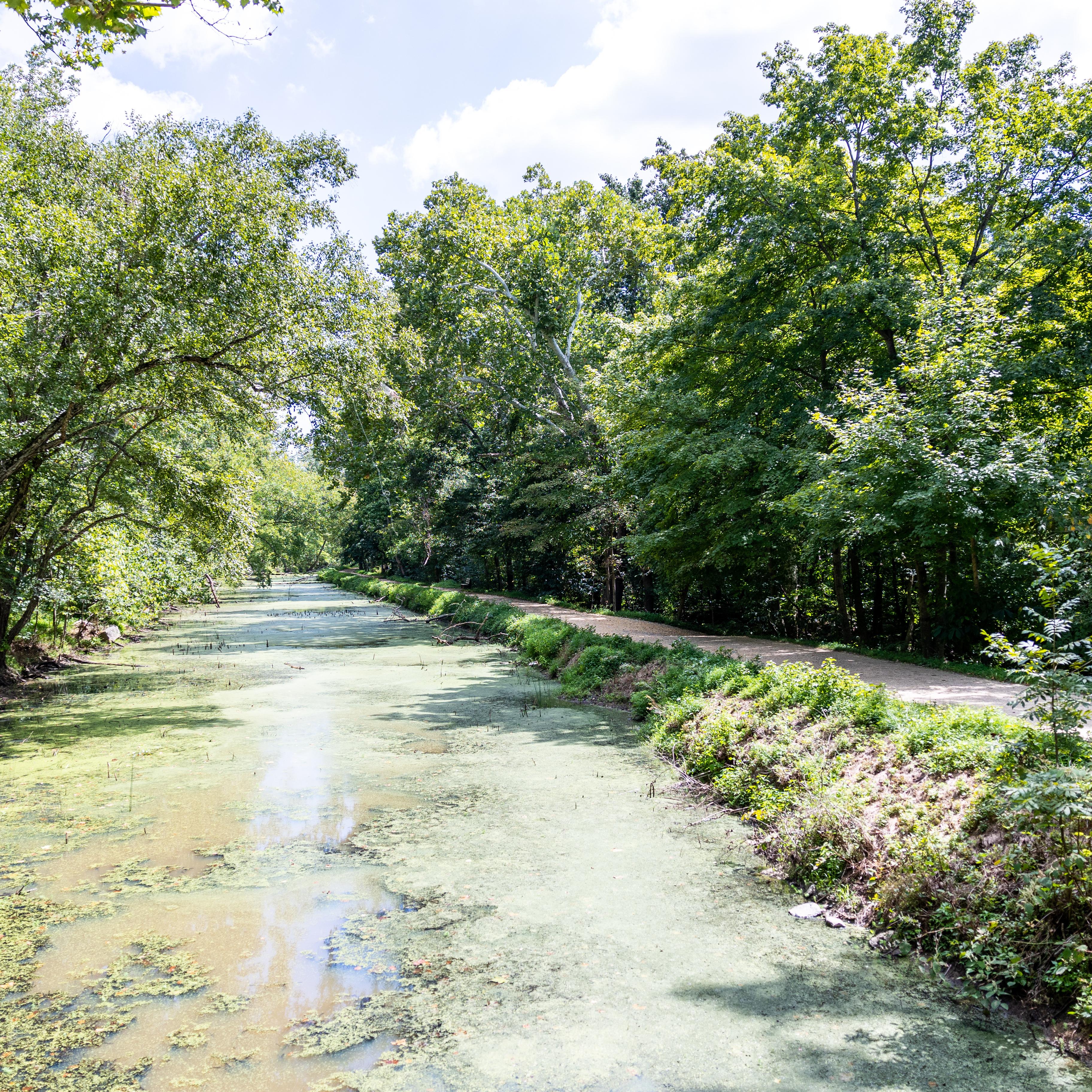 A canal filled with water next to a path