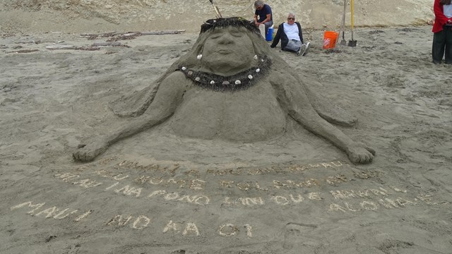 A sand sculpture of the head and upper torso of a Hawai'ian woman wearing a flower crown.