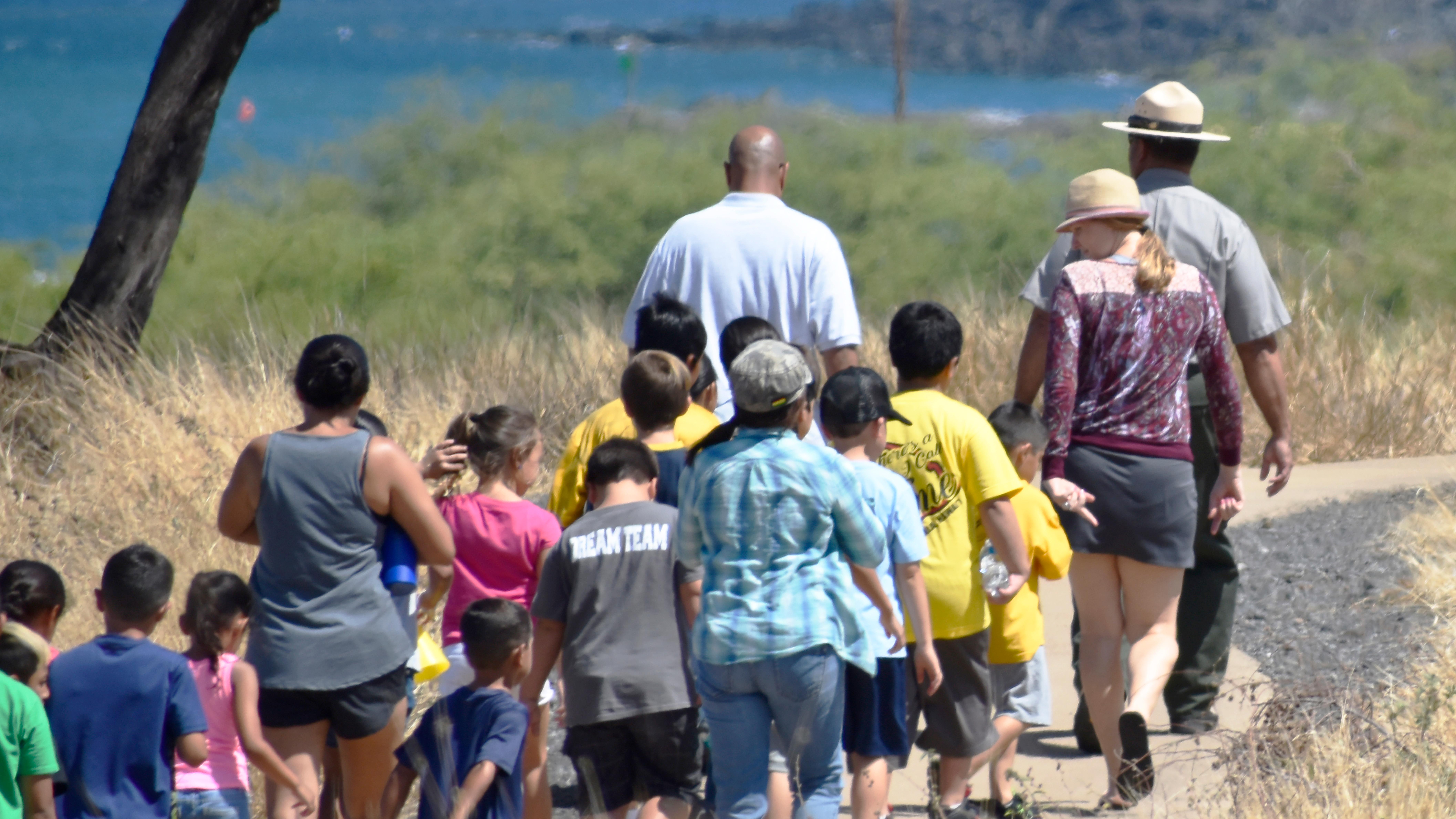 Park ranger leading a group of kids along the trail