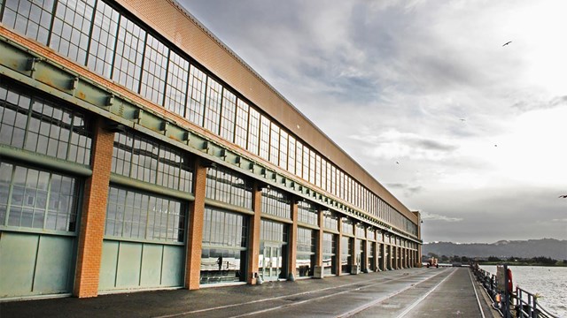 A large rectangular building with windows from top to bottom. Waterfront view. 