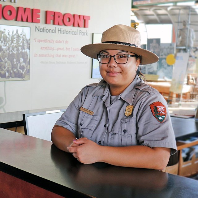 Image of female ranger at the front desk of the visitor center. 
