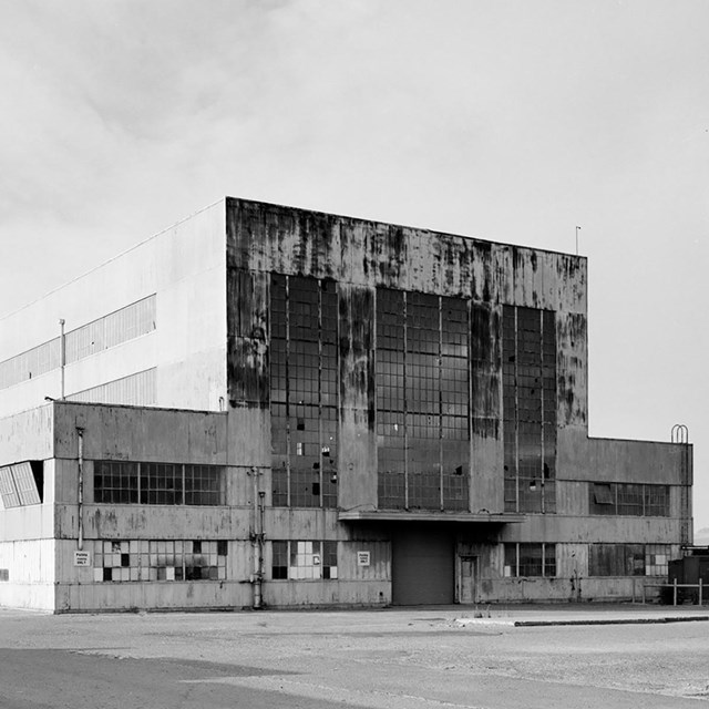 An historic photo of a large, multi-story industrial building with lots of windows. 