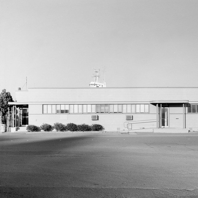 A historic photo of a single story rectangular building. 