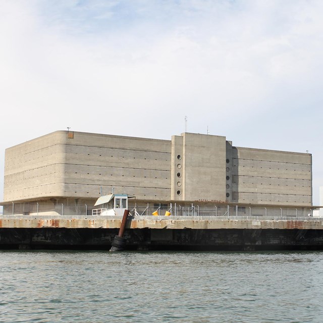 A historic multi-story building sitting by the waterfront. 