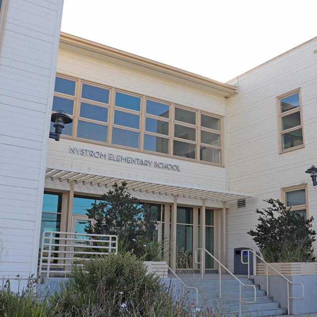 An entrance way to a two story building. Windows on the lower and upper entrances.