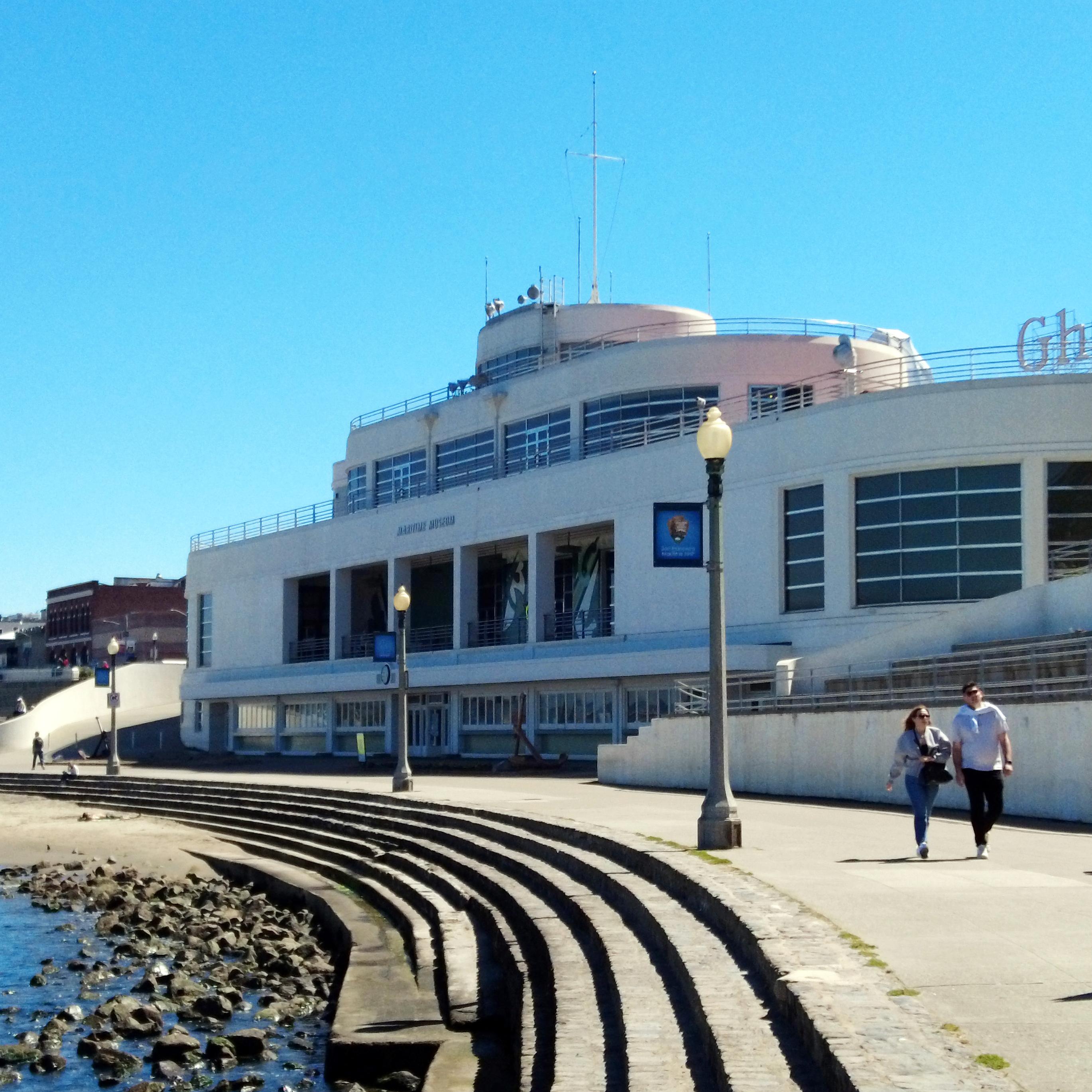 a white building designed to look like an ocean liner ship near a rocky shoreline