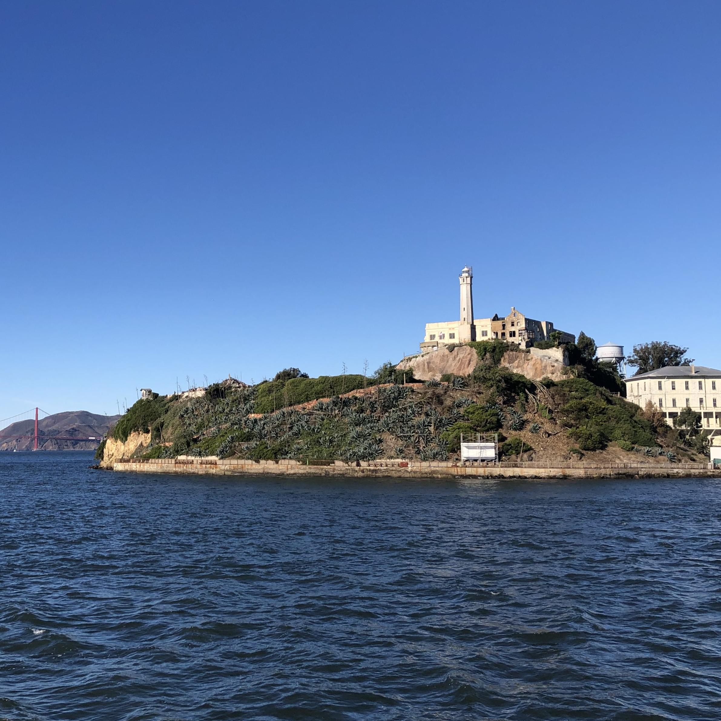 Alcatraz Island as seen from a ferry boat, with Golden Gate Bridge in the background.