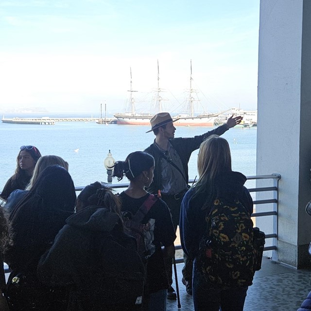 a Park Ranger gives a talk facing a group of visitors.