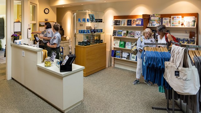 gift store with shelfs of books and clothes hanging