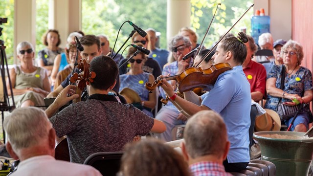 string quartet plays outside as people in seats listen