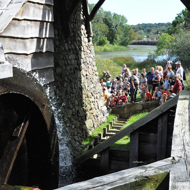 group of visitors watching a waterwheel turn