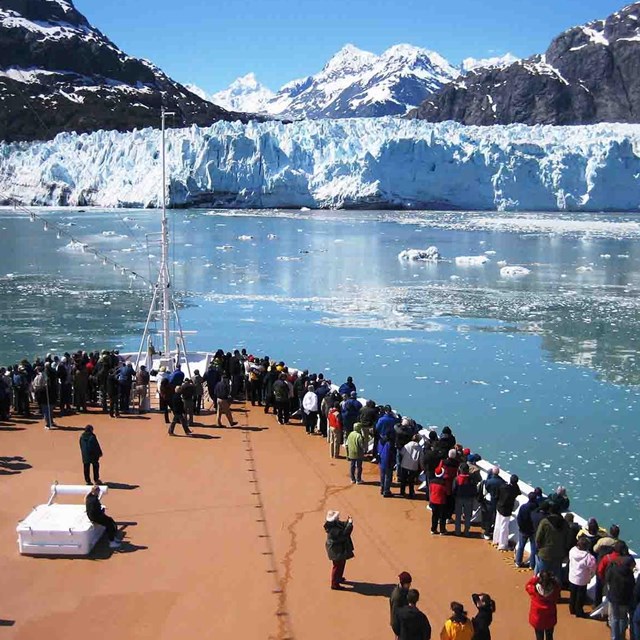Visitors on a cruise ship view a tidewater glacier.