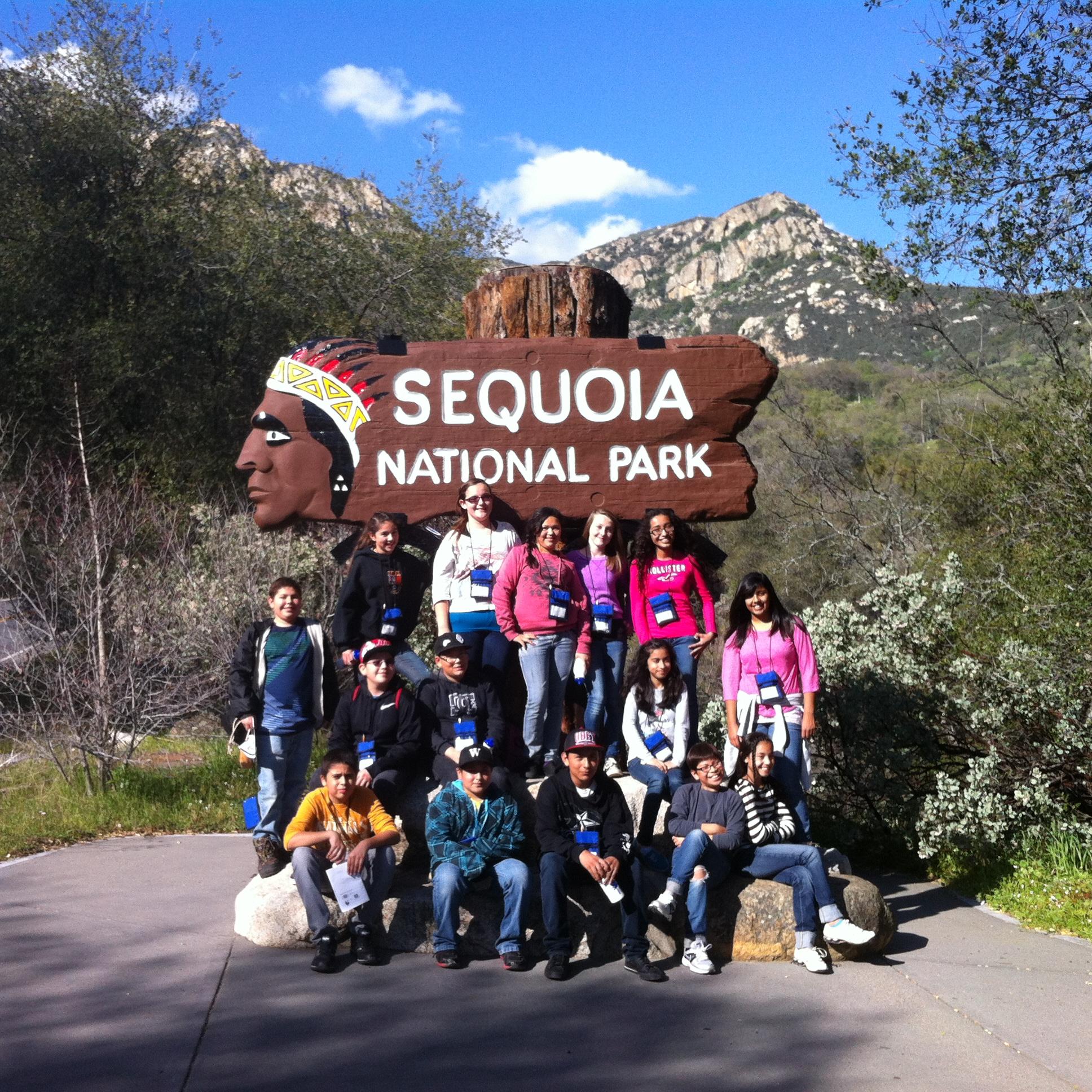 Kids pose in front of the historic park entrance sign