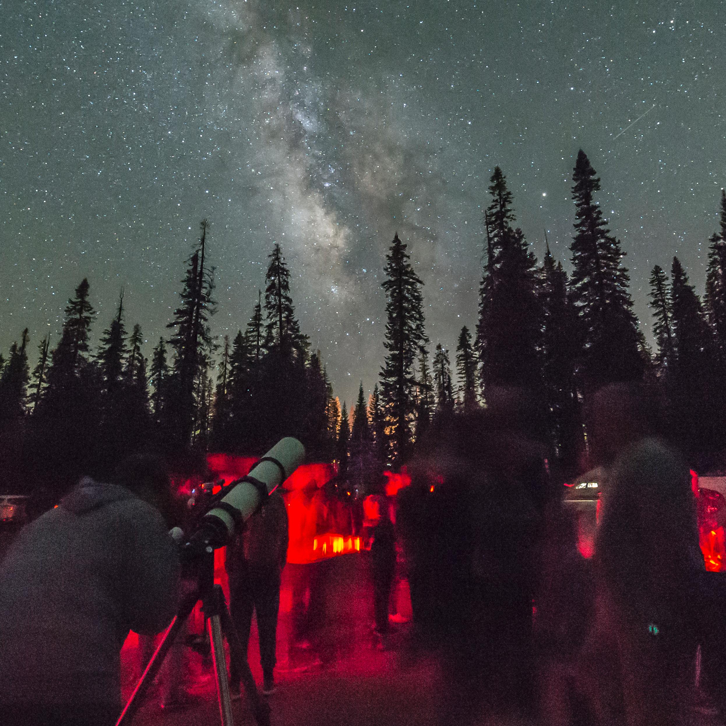People sit at night under a starry sky