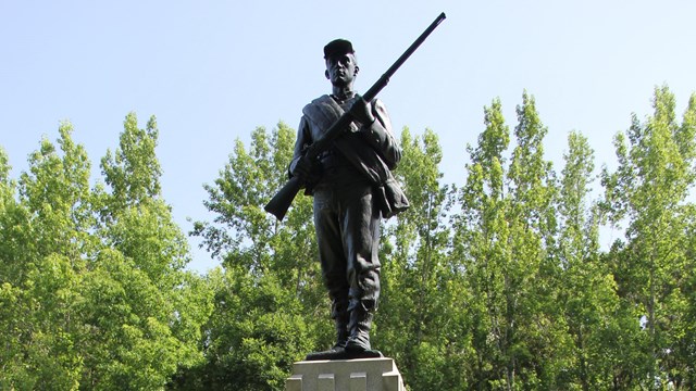 Bronze statue of a soldier holding a musket. 