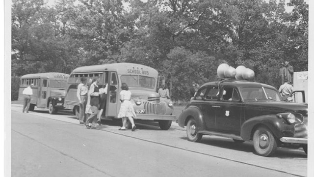 Historic image of a car leading buses around Shiloh
