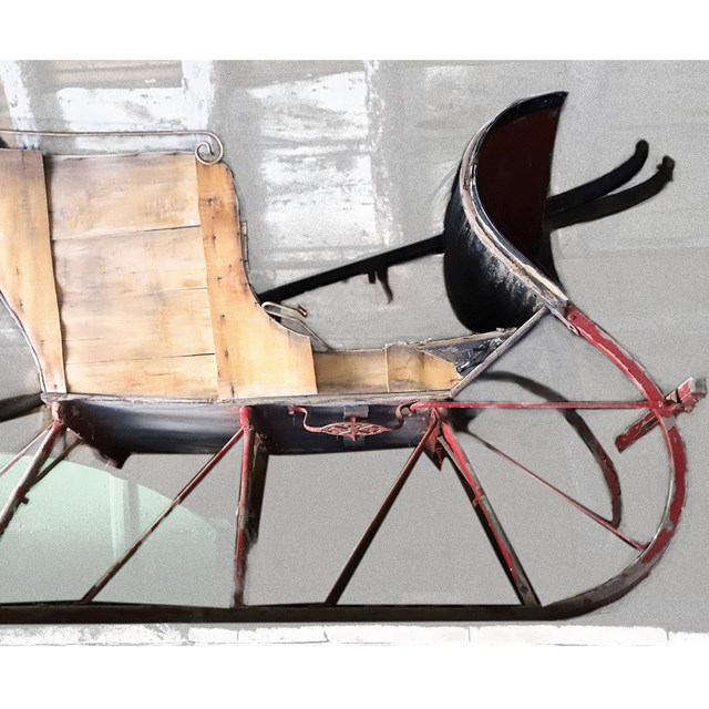 Wooden winter sleigh with aged red-painted rails