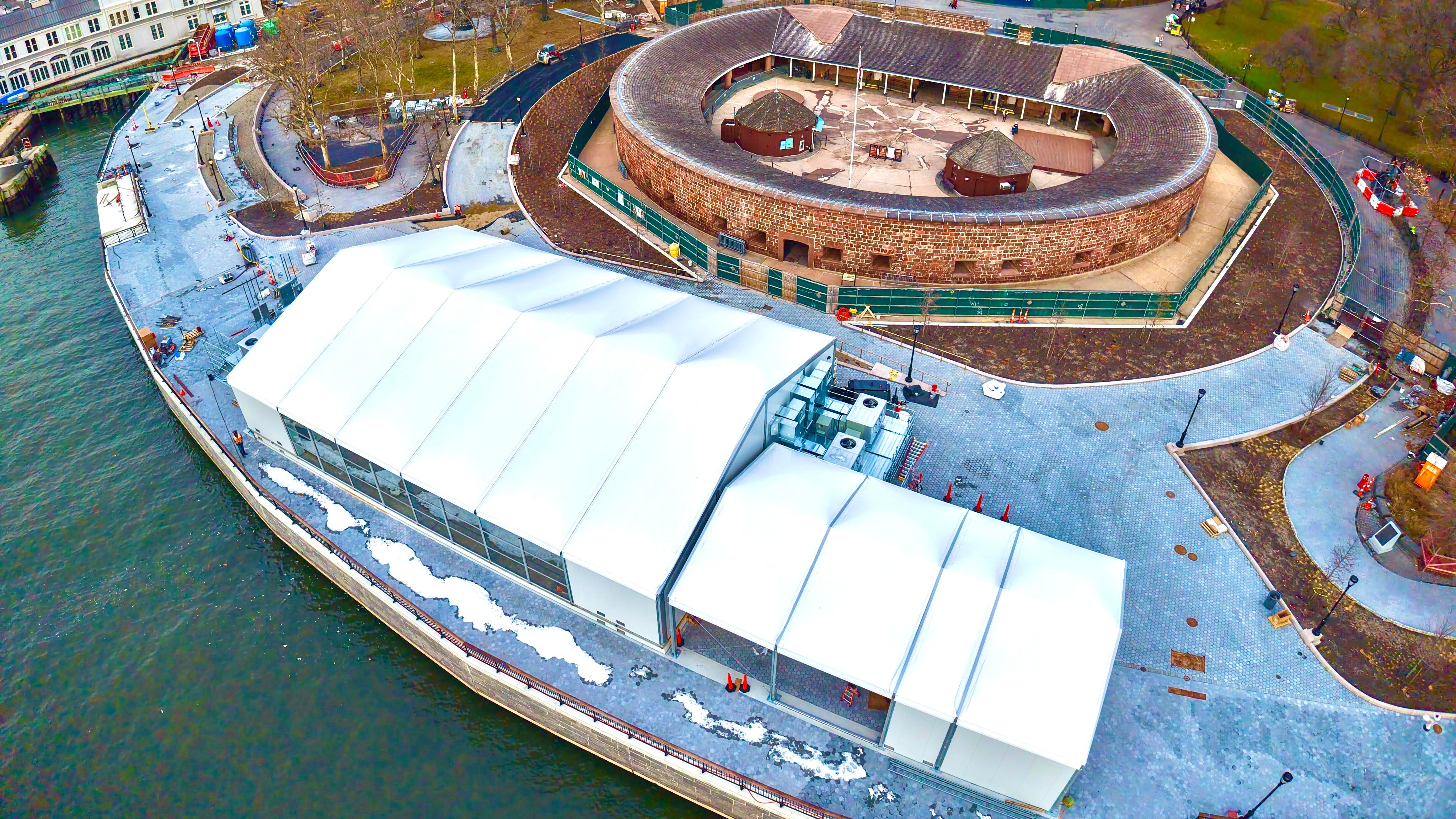 An aerial view of the white security building next to an oval structure.