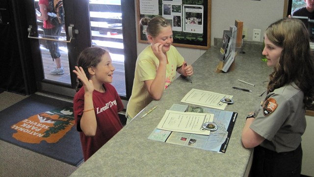 Ranger swearing in two young girls as Junior Rangers.
