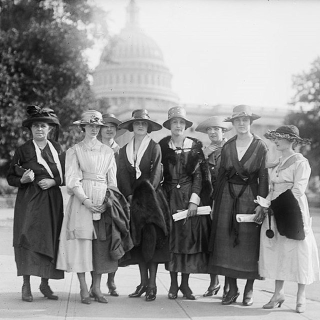 Women standing in front of Capitol Building. 