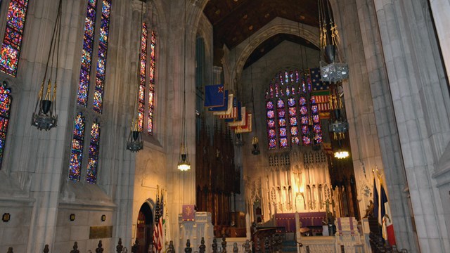 A spacious chapel interior with large stained glass windows.