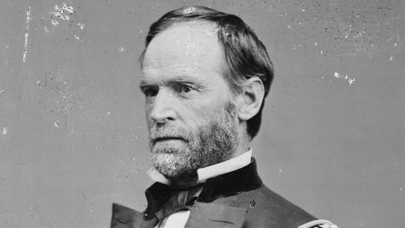 A black and white image of William T. Sherman sitting in Union general's uniform jacket unbuttoned.