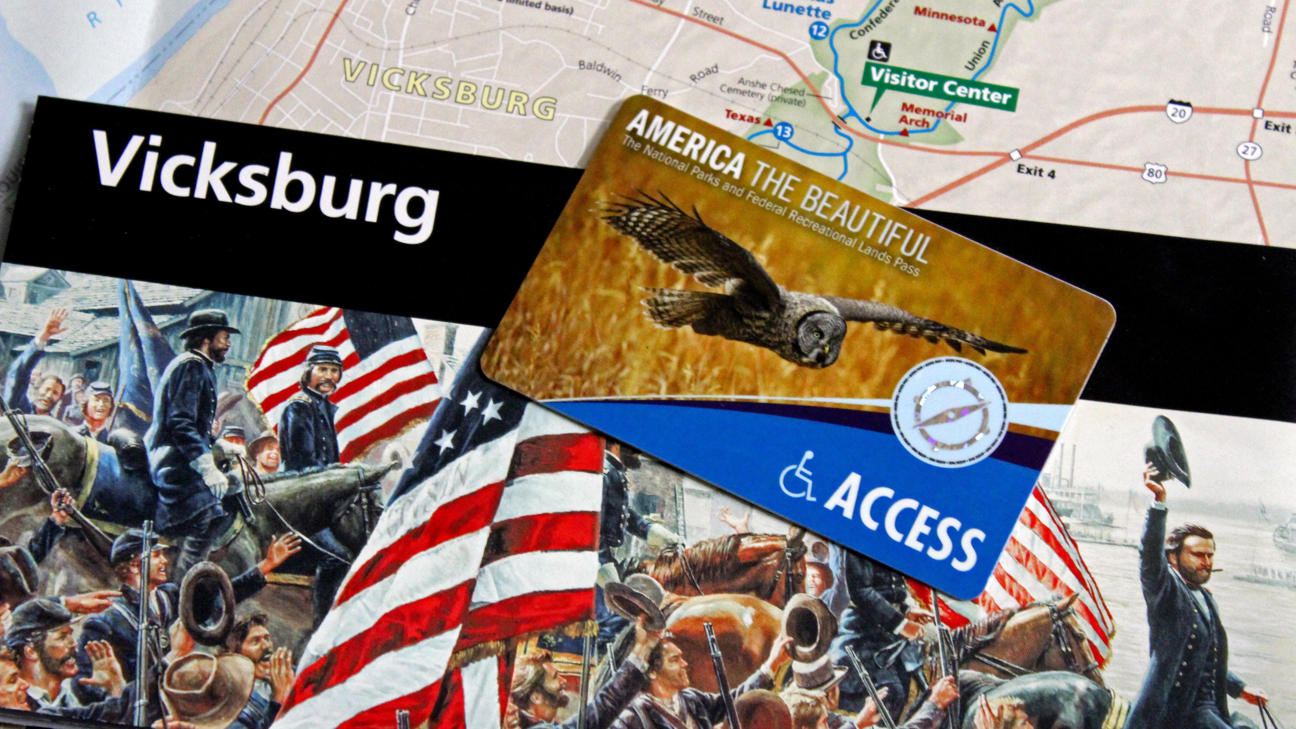 An America the Beautiful Access pass lying on top of a park brochure.