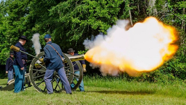 Park rangers and volunteers fire a 12 pound Napoleon cannon during a living history demonstration. 