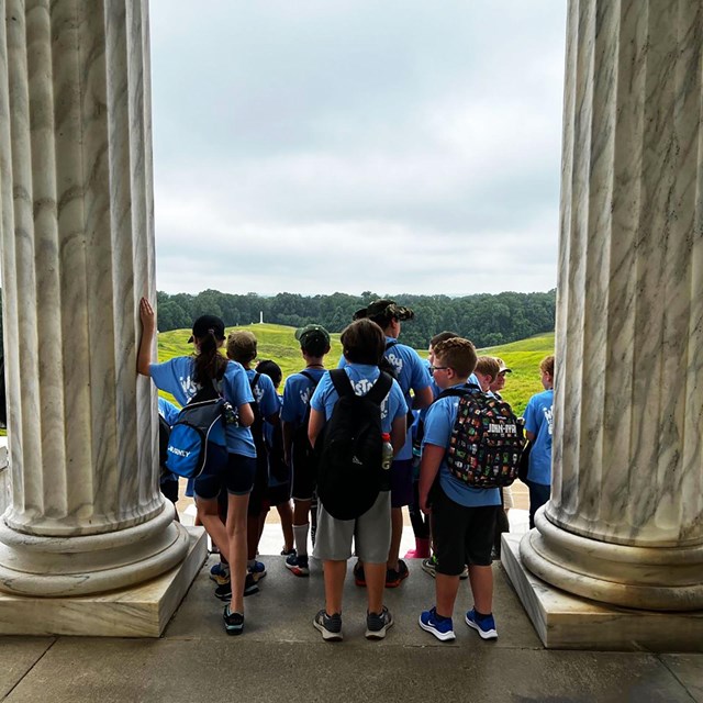Students stand atop steps looking out at the battlefields