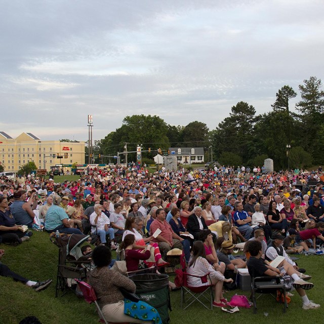 A large group of visitors sitting at a concert.