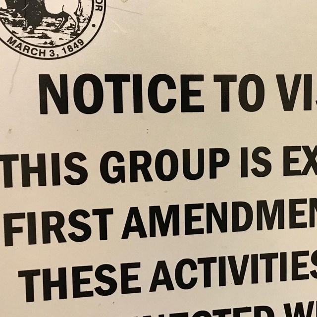 A sign giving notice to visitors that a group is expressing their first amendment rights.