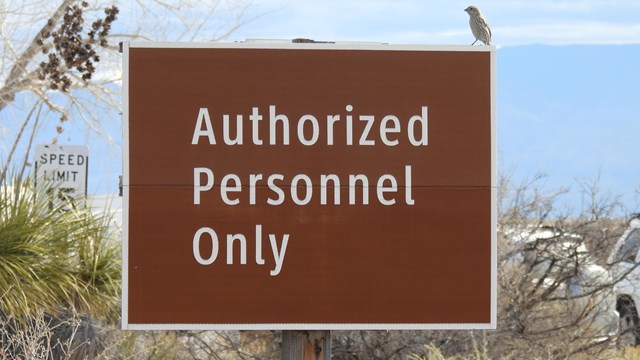 A brown sign reading "Authorized Personnel Only"