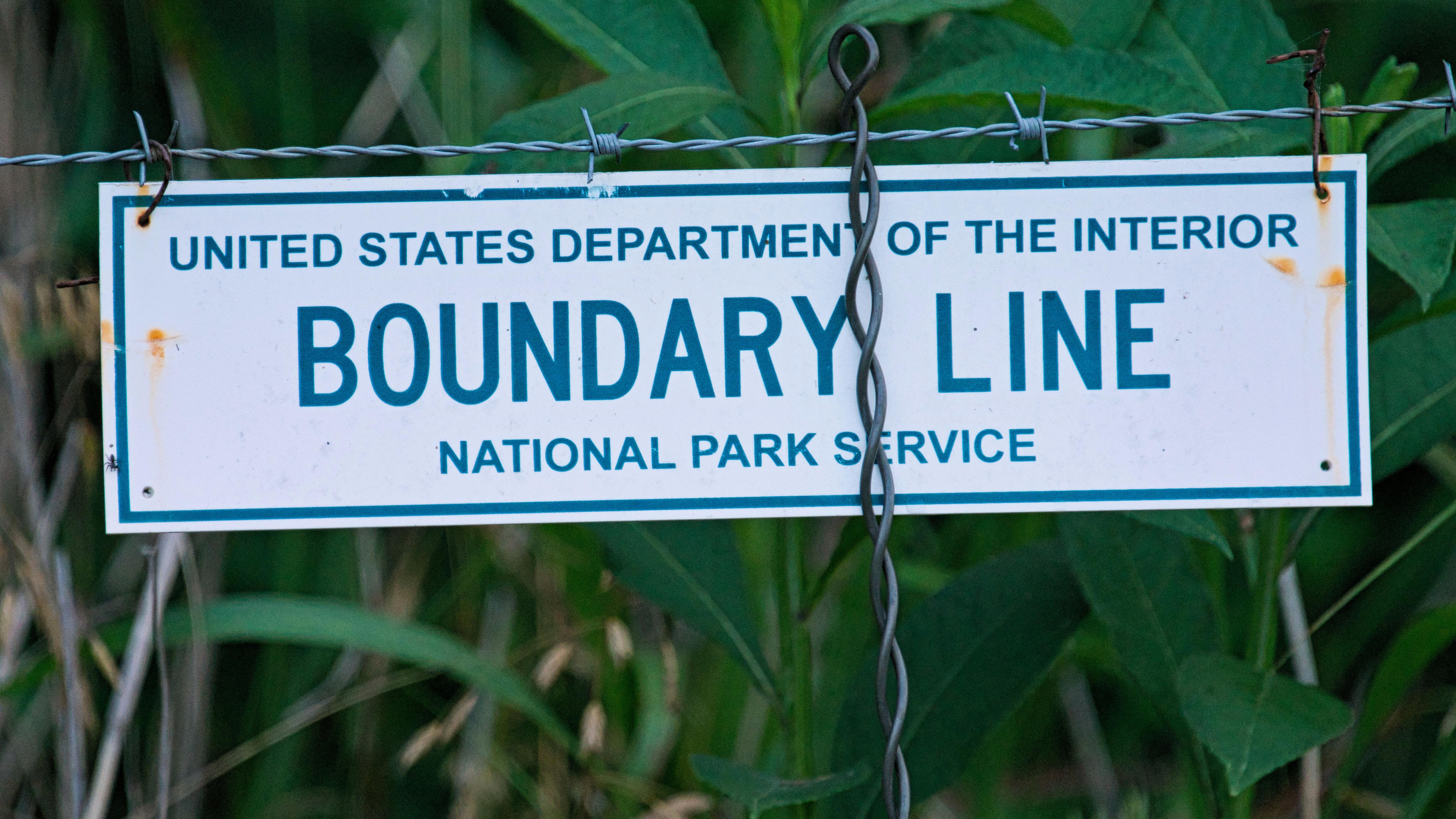 Sign on a fence reads United State Department of the Interior Boundary Line" 