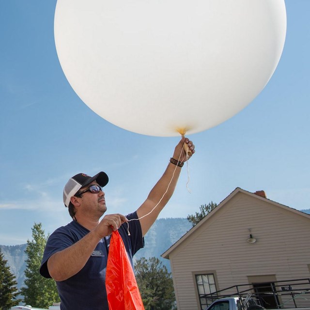 Two people send up a weather balloon