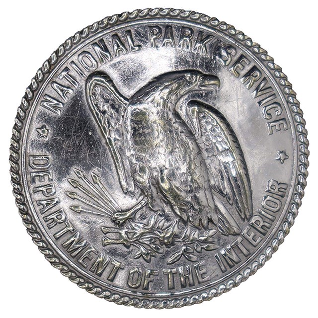 An image of a button with an eagle surrounded by the words: National Park Service, DOI