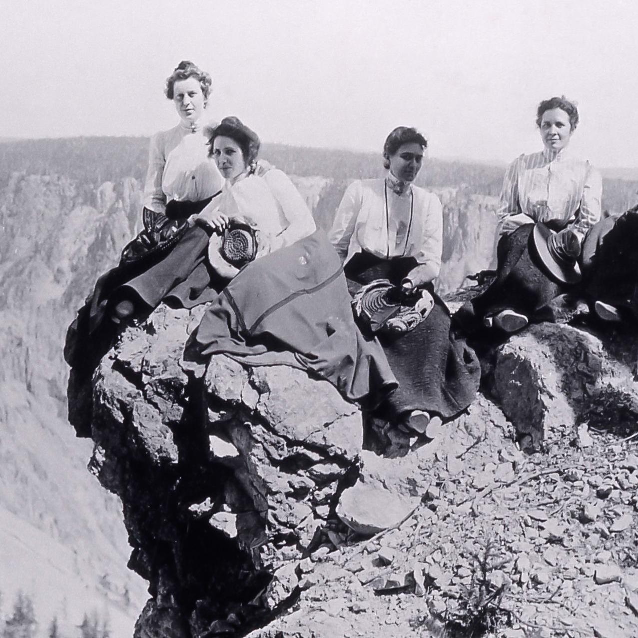 Historic photograph of employees sitting on the rim of a canyon