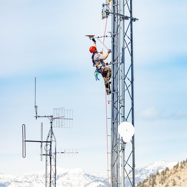 a man climbing a communications tower