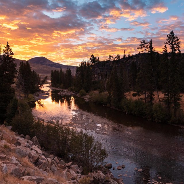 Orange sunrise over a meandering river.