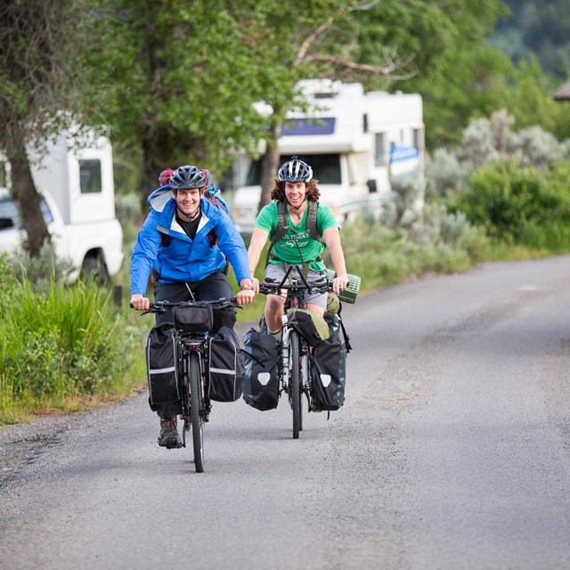 Cyclists pedal around a campground