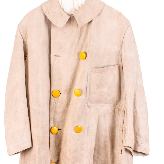 Cream colored long jacket with buttons running down the front