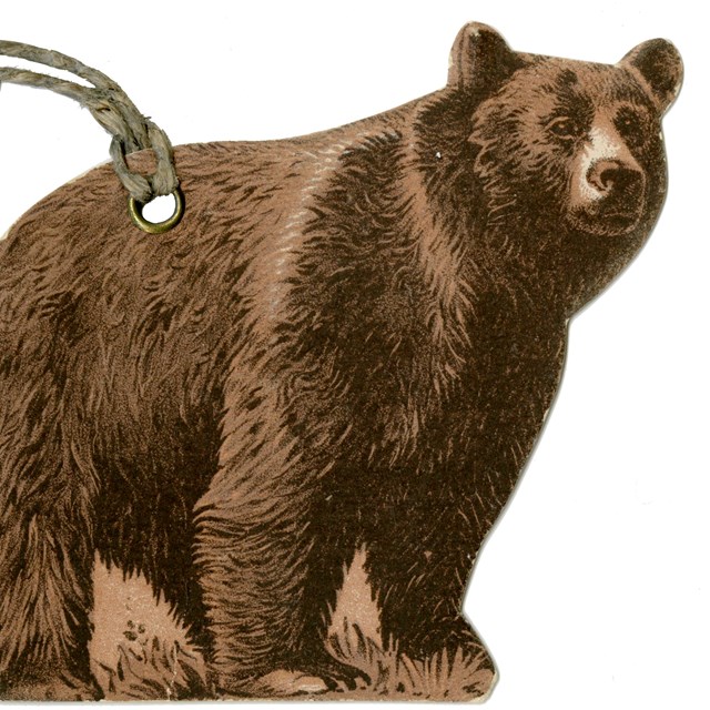 PAPER LUGGAGE IDENTIFICATION TAG IN THE SHAPE OF A BEAR STANDING