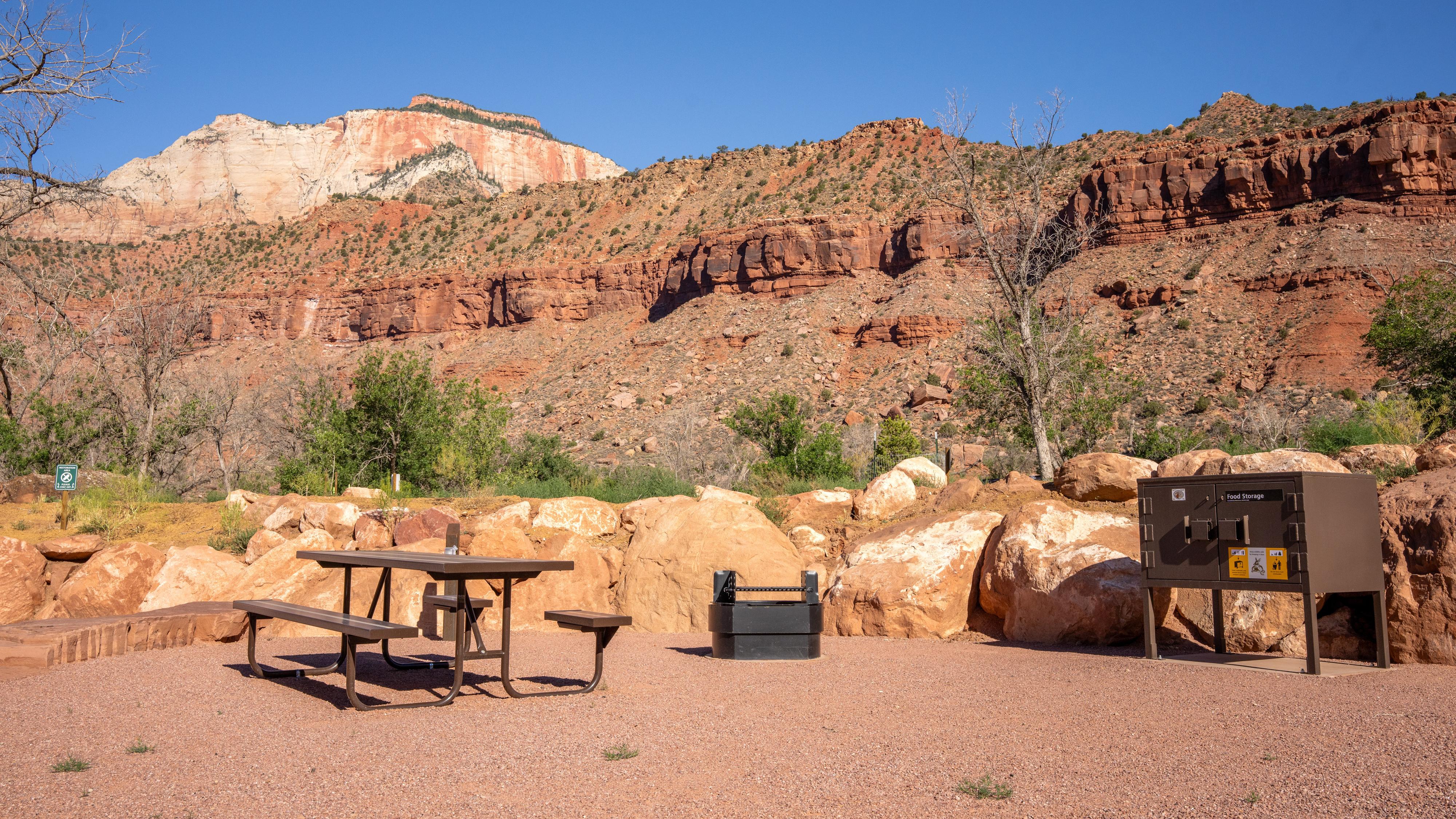 A picnic table and elevated fire pit on a flat surface.