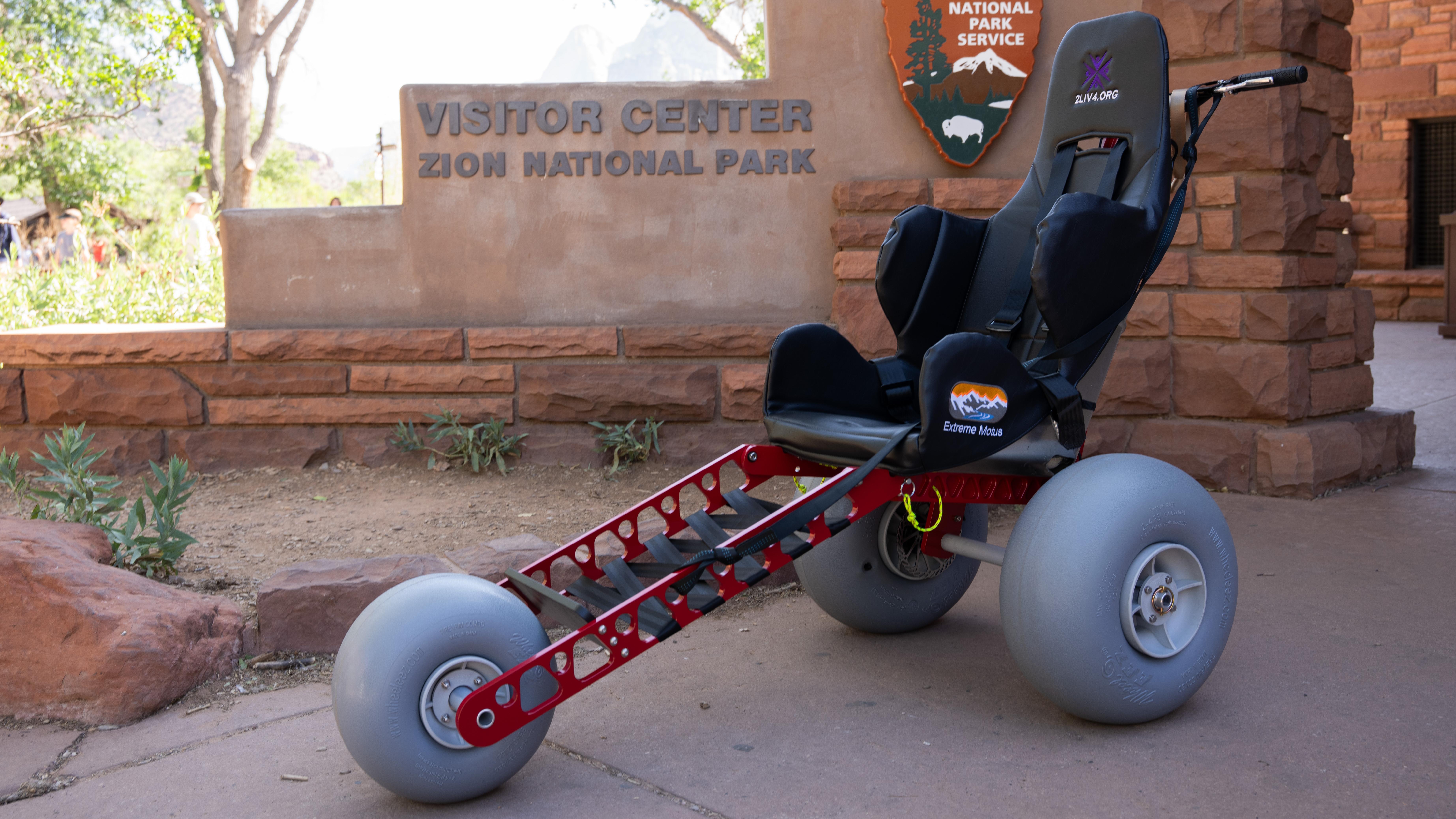 An adventure wheelchair with large tires sits in front of the Zion Canyon Visitor Center.