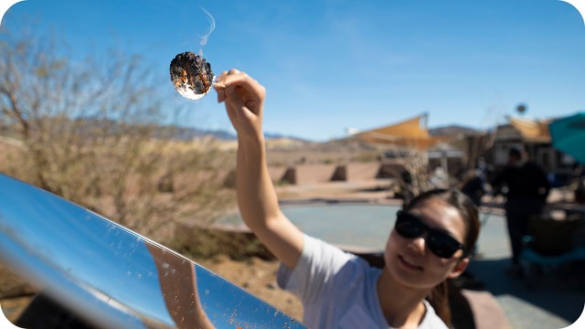 A person in the foreground is engaged in an outdoor scientific experiment.