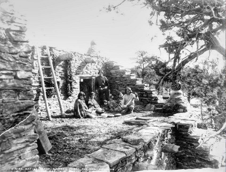 A stone structure with people, trees, and a ladder